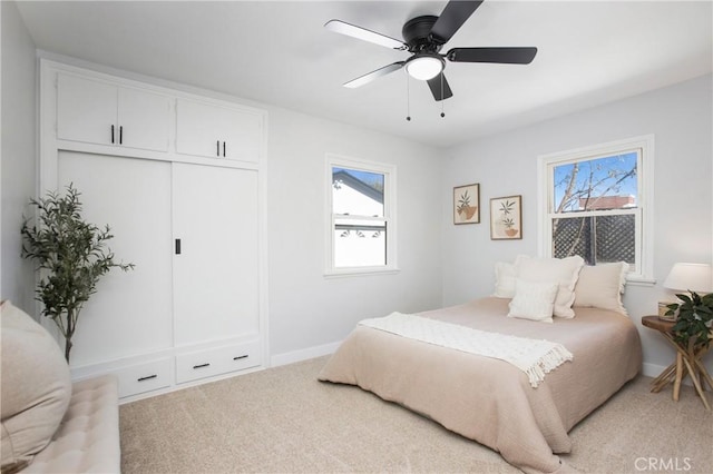 carpeted bedroom featuring ceiling fan and a closet