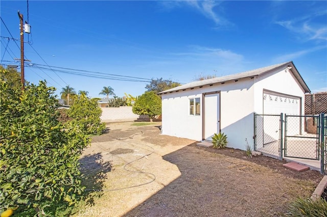 exterior space featuring a garage and an outbuilding