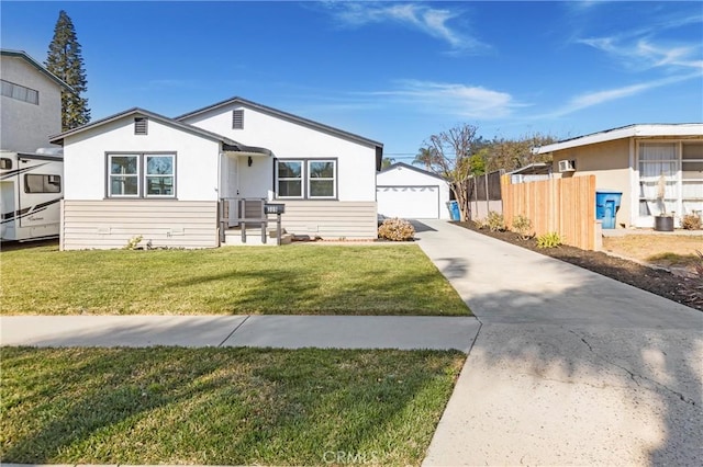 view of front of home with a garage, a front lawn, and an outbuilding