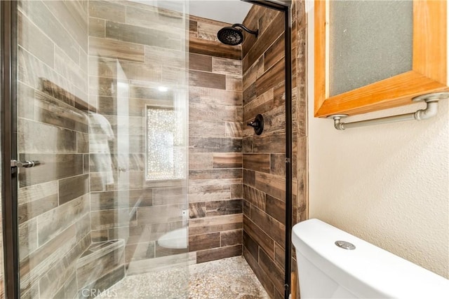 bathroom featuring toilet and tiled shower