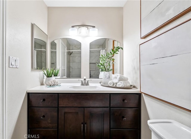 bathroom with toilet, walk in shower, and vanity