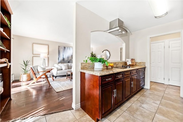 kitchen featuring light tile patterned floors, light stone countertops, and black electric stovetop