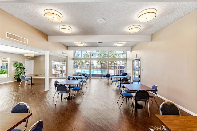 dining space with beamed ceiling and hardwood / wood-style flooring