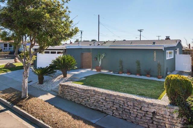 single story home featuring a garage and a front lawn