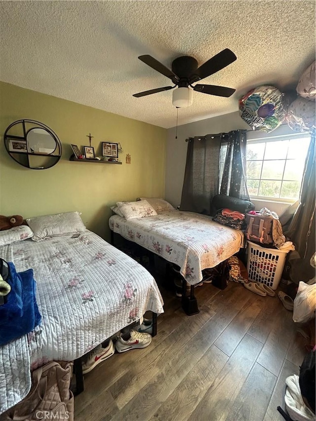 bedroom featuring ceiling fan, wood-type flooring, and a textured ceiling