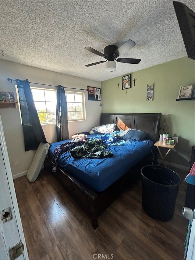 bedroom with dark wood-type flooring, ceiling fan, and a textured ceiling