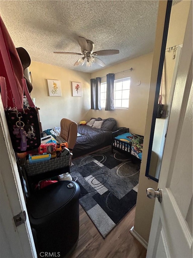 bedroom featuring a textured ceiling, ceiling fan, and hardwood / wood-style flooring