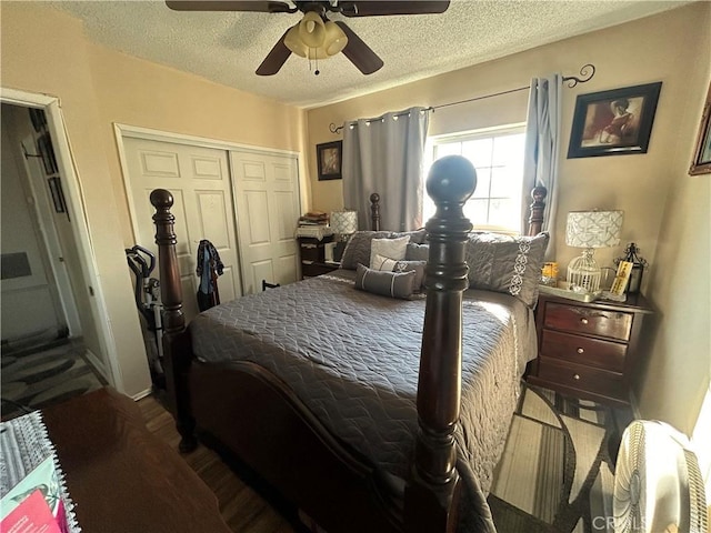 bedroom with a textured ceiling, ceiling fan, a closet, and wood-type flooring