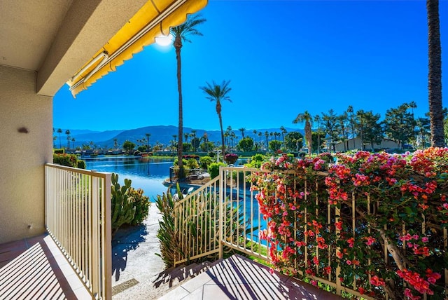 balcony featuring a water and mountain view