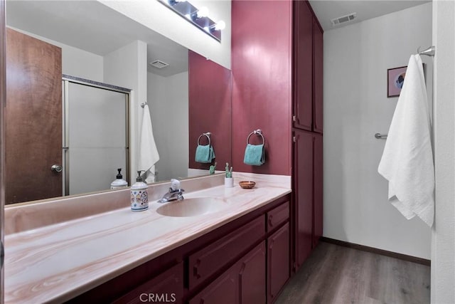 bathroom featuring walk in shower, wood-type flooring, and vanity