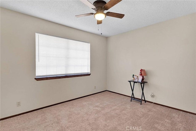 spare room with a textured ceiling, ceiling fan, and light colored carpet