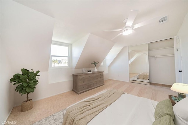 carpeted bedroom with ceiling fan, a closet, and lofted ceiling