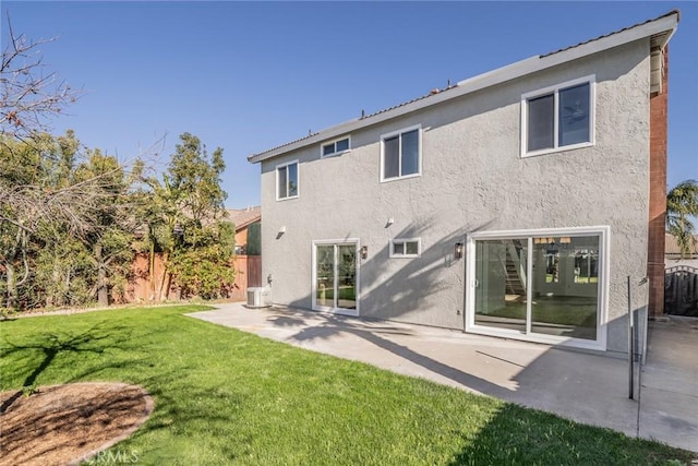 back of house featuring cooling unit, a lawn, and a patio