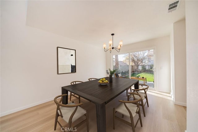 dining area with a notable chandelier and light hardwood / wood-style floors