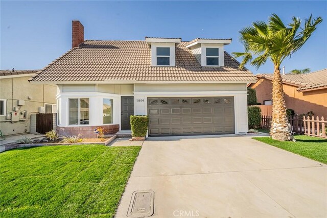 mediterranean / spanish-style home featuring a front yard and a garage