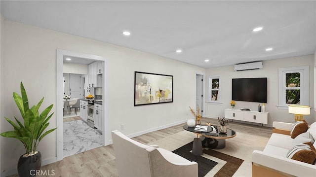 living room featuring light wood-type flooring and an AC wall unit