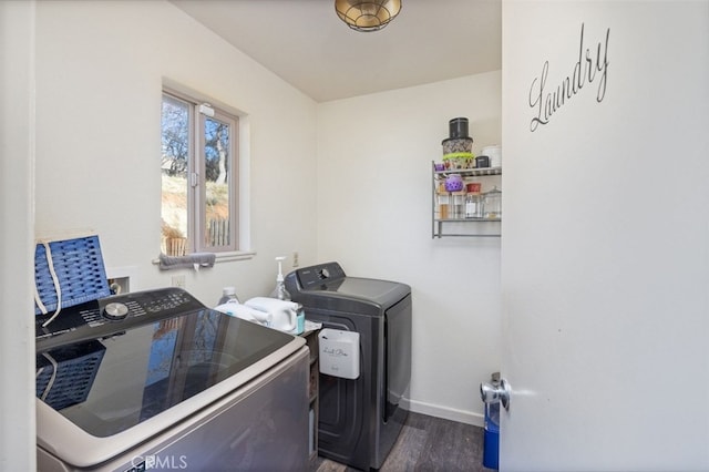 clothes washing area with dark hardwood / wood-style flooring and separate washer and dryer