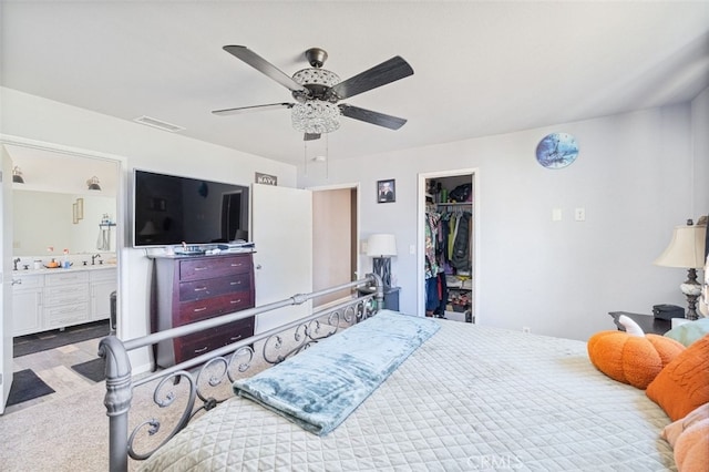 carpeted bedroom with ceiling fan, a closet, a spacious closet, and connected bathroom