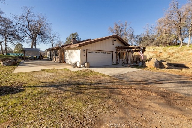 view of front of property featuring a pergola and a garage