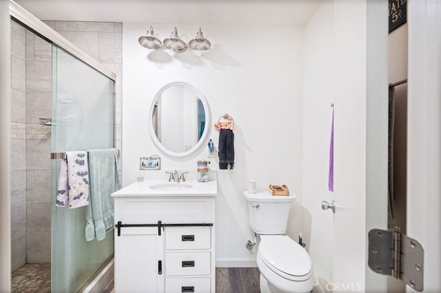 bathroom with toilet, a shower with door, hardwood / wood-style flooring, and vanity