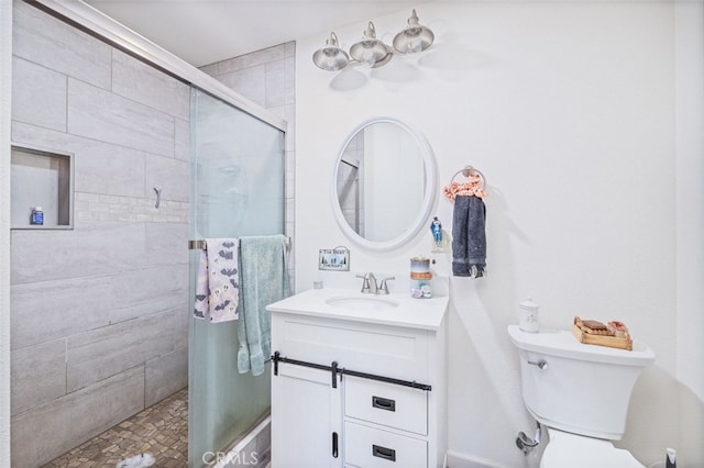 bathroom featuring a shower with door, toilet, and vanity