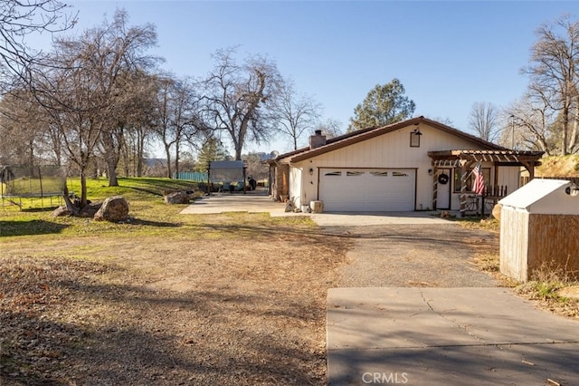 view of front of property featuring a garage and a pergola