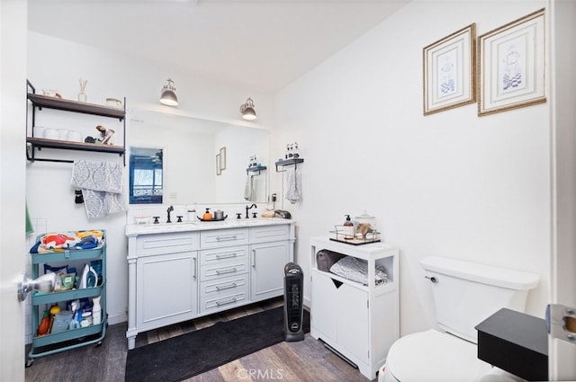 bathroom with toilet, wood-type flooring, and vanity