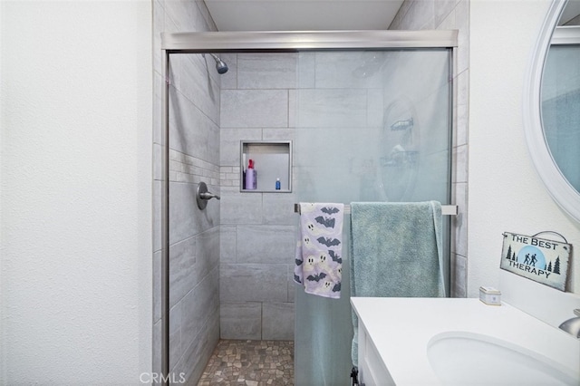 bathroom featuring walk in shower and vanity