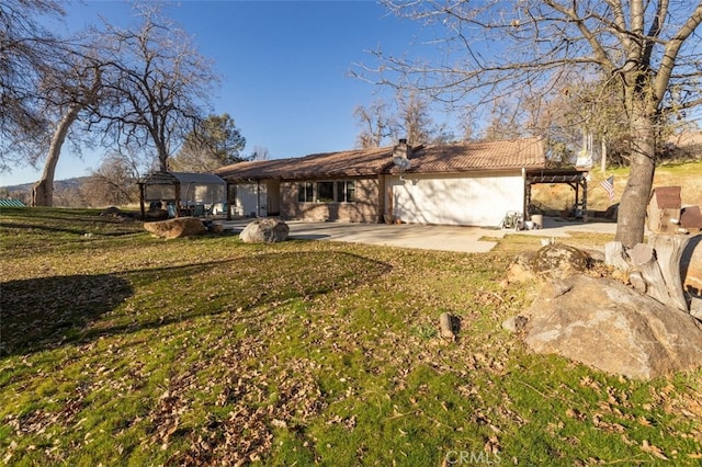 single story home featuring a front lawn and a patio area