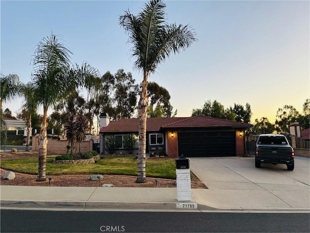 view of front of home with a garage and a lawn