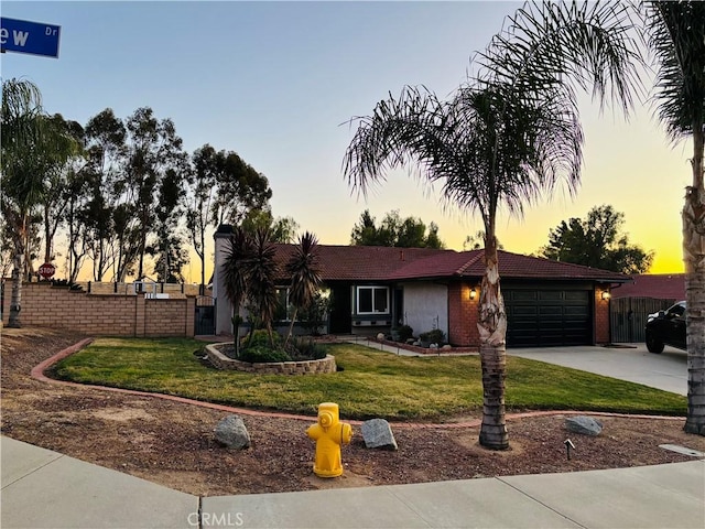 ranch-style home with a garage and a yard