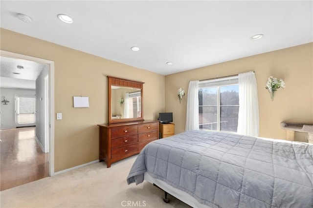 bedroom featuring light carpet and multiple windows