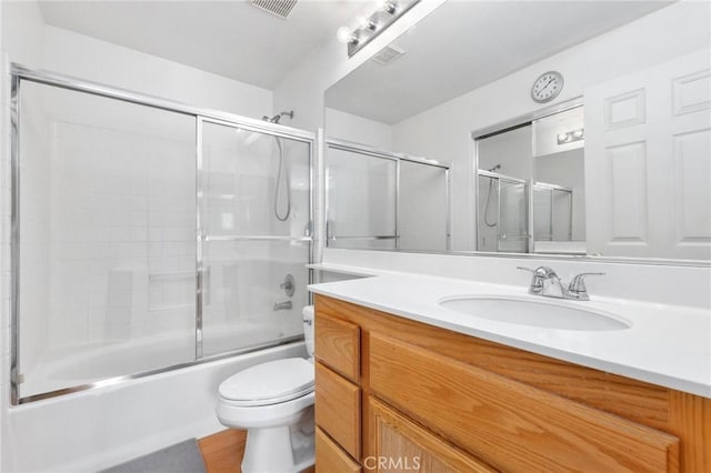 full bathroom with toilet, enclosed tub / shower combo, and vanity