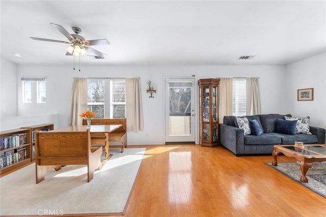 living room featuring ceiling fan, light hardwood / wood-style flooring, and a healthy amount of sunlight