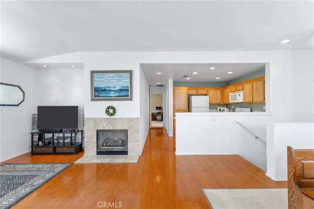 living room featuring light hardwood / wood-style floors and a tile fireplace