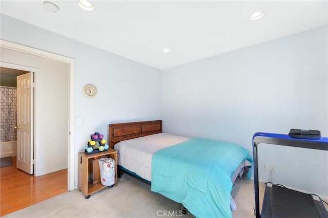 bedroom with ensuite bath and light hardwood / wood-style floors