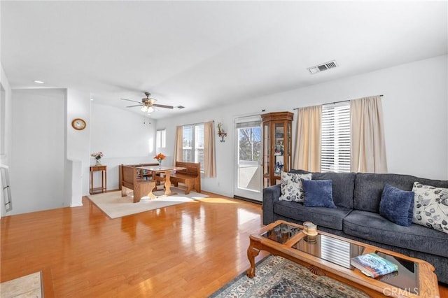 living room with ceiling fan and light hardwood / wood-style flooring