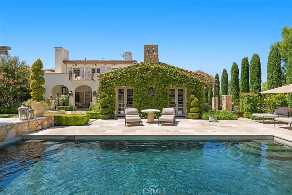 back of property featuring a patio area, french doors, and a balcony