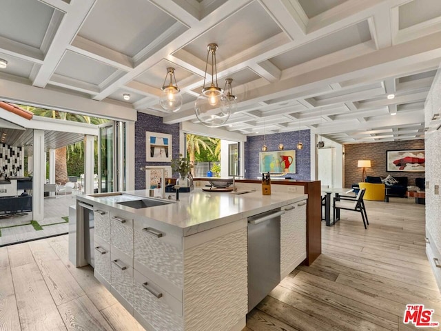 kitchen featuring a large island with sink, white cabinets, dishwasher, decorative light fixtures, and light wood-type flooring