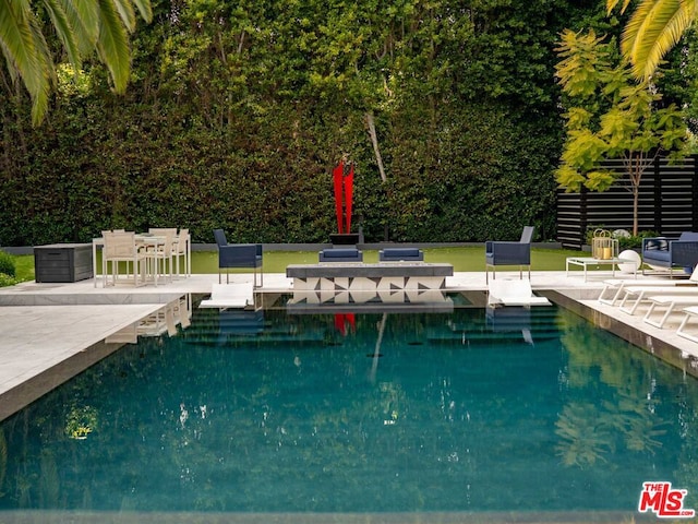 view of swimming pool with a patio area and a water view