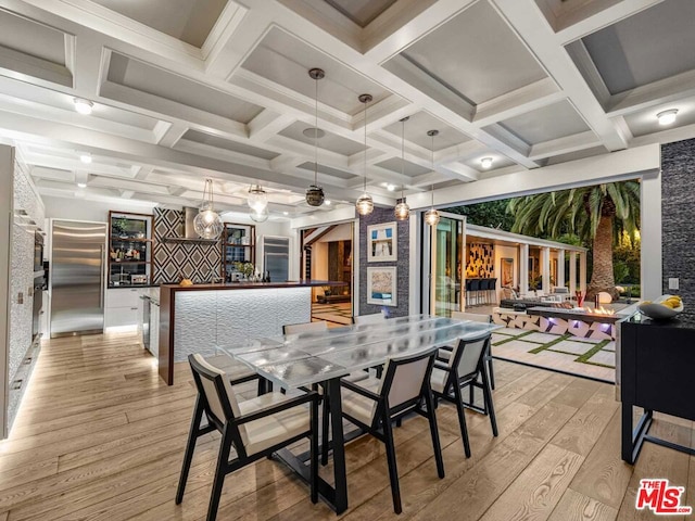 dining space with light wood-type flooring, indoor bar, and coffered ceiling