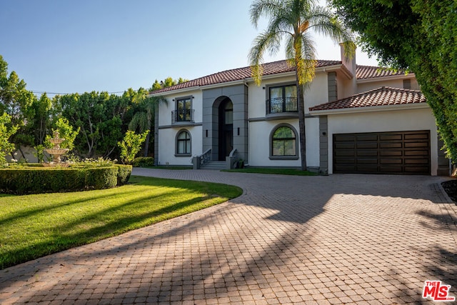 mediterranean / spanish house featuring a front lawn and a garage