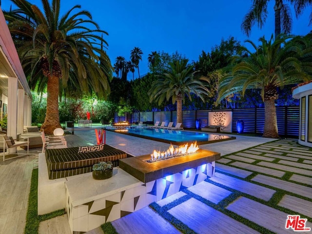 view of swimming pool featuring an outdoor fire pit and a patio