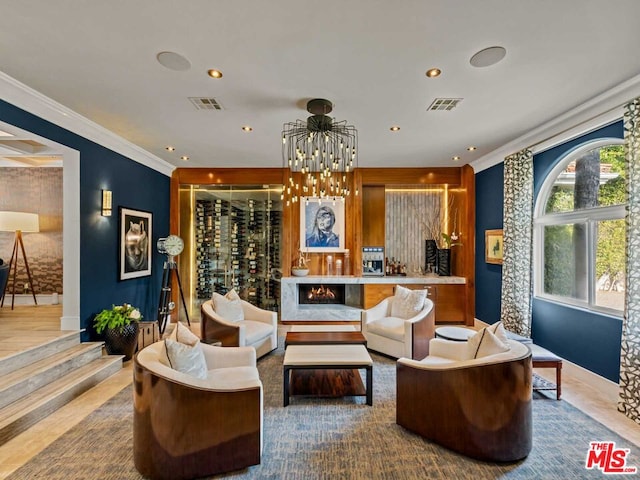 sitting room with crown molding and an inviting chandelier