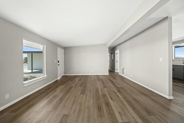 unfurnished living room with dark wood-type flooring and sink