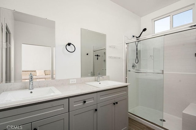 bathroom with a shower with shower door, vanity, and wood-type flooring