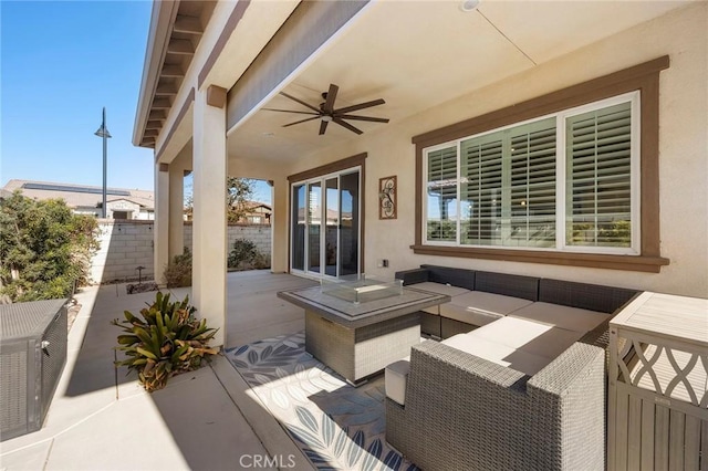 view of patio / terrace with ceiling fan and an outdoor living space with a fire pit