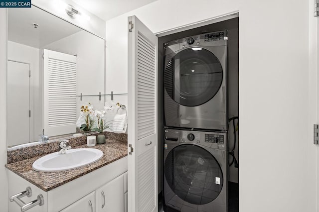 washroom featuring sink and stacked washer / drying machine