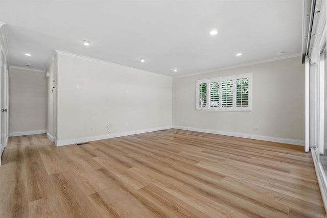 spare room featuring crown molding and light hardwood / wood-style flooring