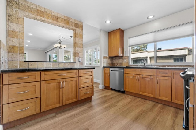 kitchen featuring dishwasher, dark stone countertops, decorative backsplash, an inviting chandelier, and light wood-type flooring